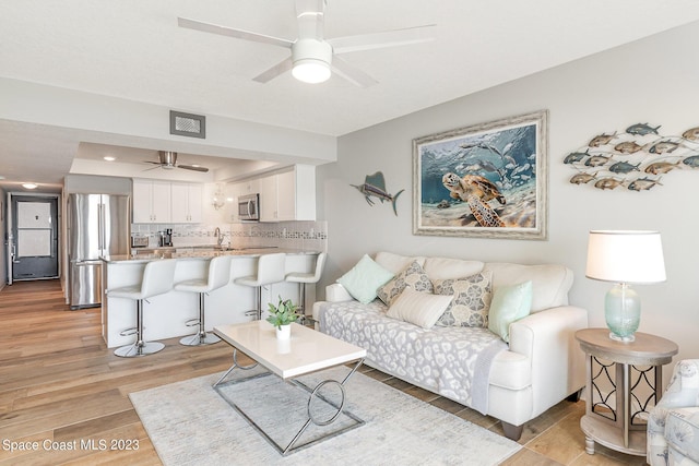 650 N Atlantic Ave # 706, Cocoa Beach, FL 32931 - living area with ceiling fan and light wood-style floors