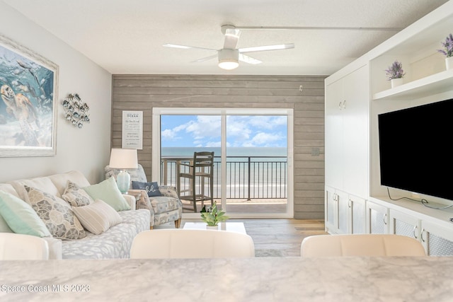 650 N Atlantic Ave # 706, Cocoa Beach, FL 32931 - living room with wooden walls, wood finished floors, and a ceiling fan