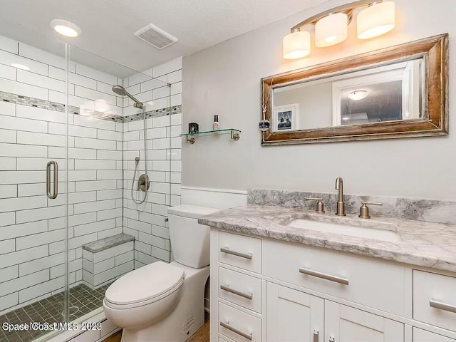 bathroom featuring a shower with door, vanity, and toilet