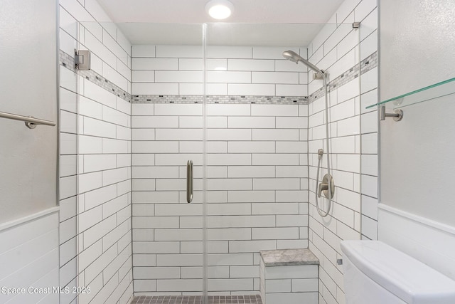 650 N Atlantic Ave # 706, Cocoa Beach, FL 32931 - bathroom with a stall shower, wainscoting, and tile walls