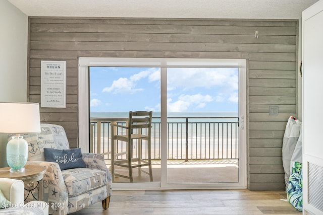 interior space featuring wood walls, a water view, and light hardwood / wood-style flooring