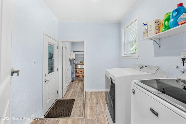 laundry room featuring washer and dryer, ornamental molding, and light hardwood / wood-style flooring