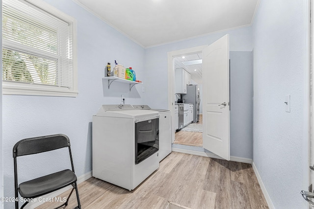 clothes washing area with independent washer and dryer, light wood-type flooring, and ornamental molding