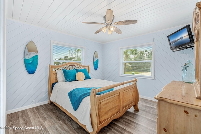 bedroom with wooden ceiling, ceiling fan, wood-type flooring, and multiple windows