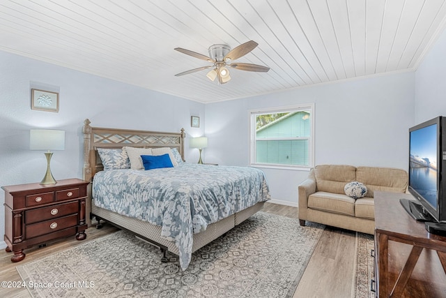 bedroom with ceiling fan, light wood-type flooring, crown molding, and wooden ceiling