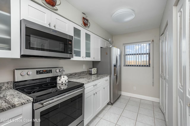 kitchen with white cabinets, light stone countertops, and stainless steel appliances