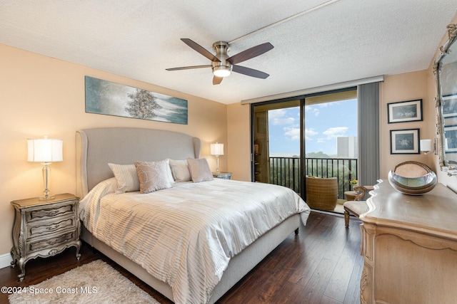 bedroom with dark wood-type flooring, ceiling fan, access to exterior, a textured ceiling, and a wall of windows