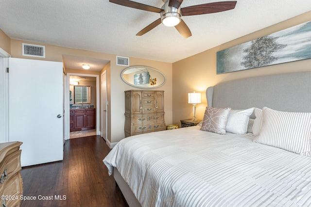 bedroom with connected bathroom, ceiling fan, dark hardwood / wood-style flooring, and a textured ceiling