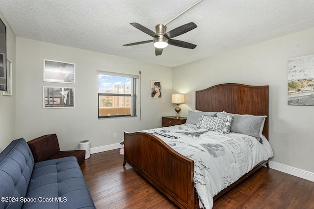 bedroom with a textured ceiling, dark hardwood / wood-style floors, and ceiling fan