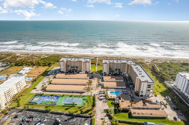 birds eye view of property with a water view and a beach view