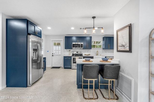 kitchen with decorative light fixtures, a kitchen breakfast bar, stainless steel appliances, and a wealth of natural light