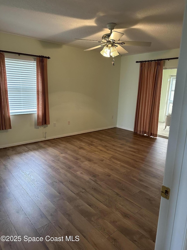 spare room with a textured ceiling, dark hardwood / wood-style floors, and ceiling fan