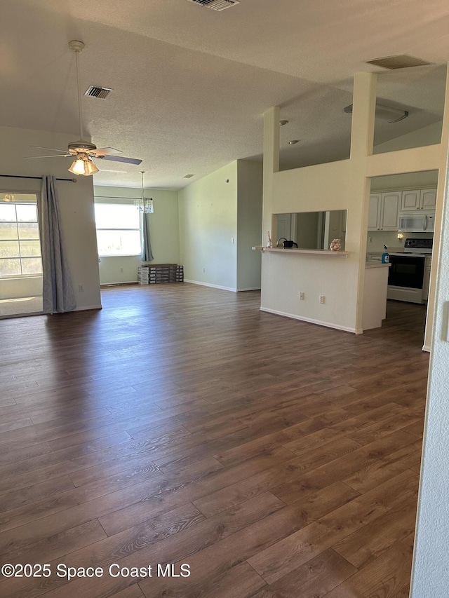 unfurnished living room featuring dark wood finished floors, visible vents, a ceiling fan, a textured ceiling, and baseboards