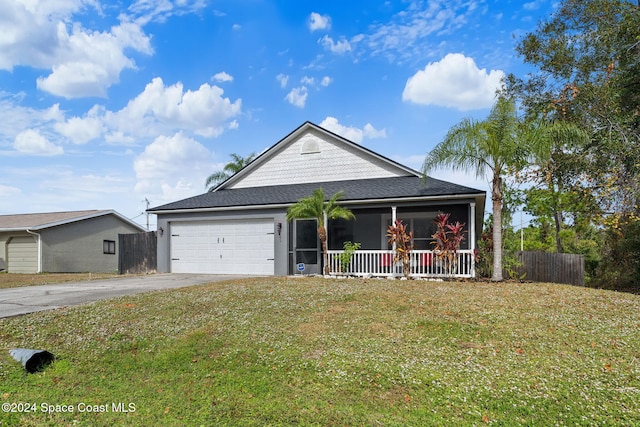 view of front of property with covered porch, a garage, and a front lawn