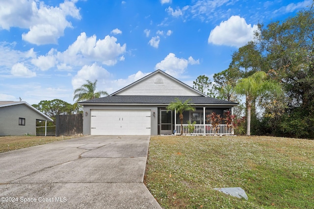 view of front of house featuring covered porch, a garage, and a front lawn