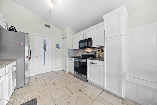 kitchen with lofted ceiling, white cabinets, decorative backsplash, light tile patterned flooring, and stainless steel appliances