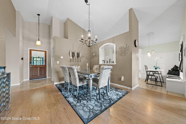 dining room with a chandelier, high vaulted ceiling, and light hardwood / wood-style floors