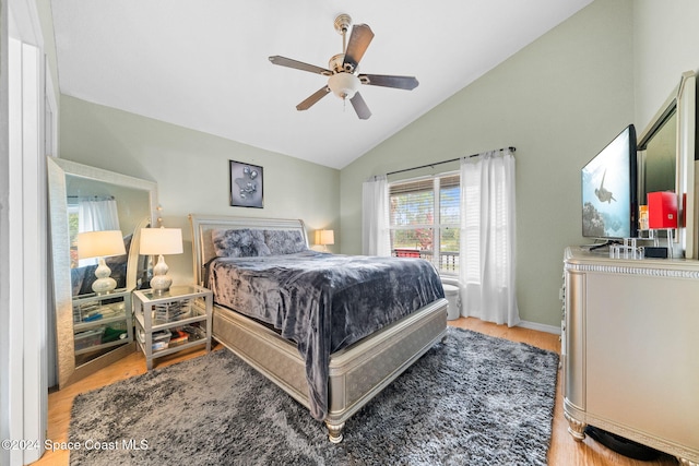 bedroom featuring light hardwood / wood-style flooring, ceiling fan, and lofted ceiling