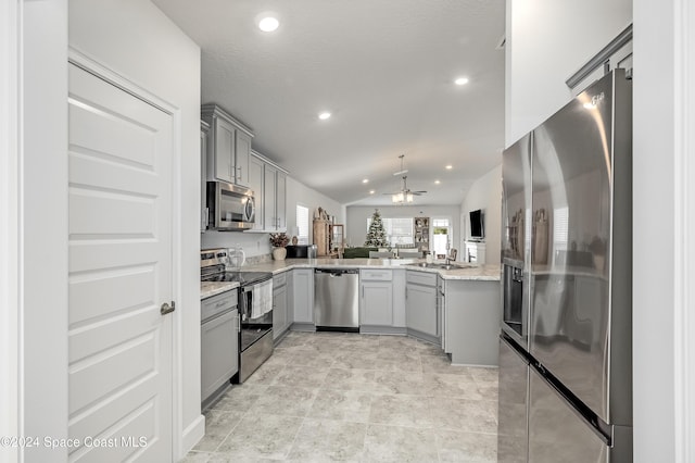 kitchen featuring gray cabinetry, vaulted ceiling, ceiling fan, a textured ceiling, and stainless steel appliances