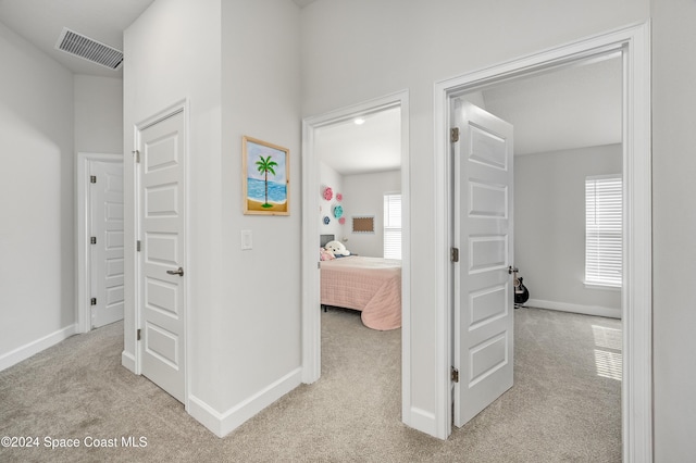 hallway with light colored carpet