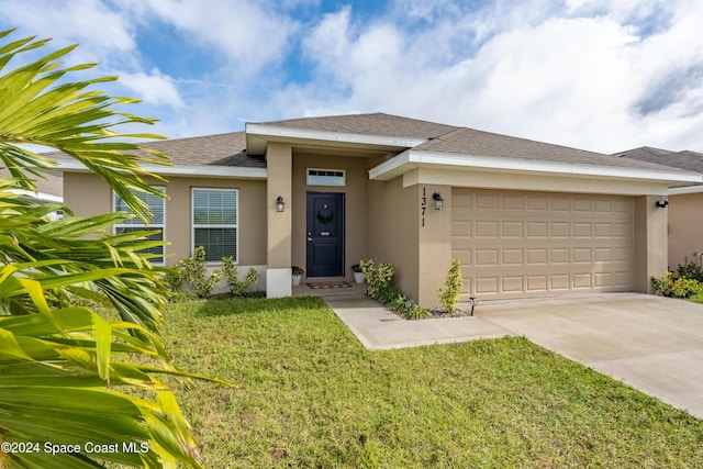 view of front of property with a front lawn and a garage