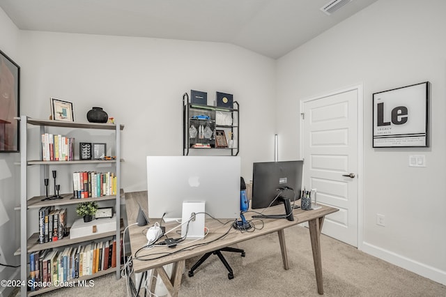 carpeted home office with vaulted ceiling