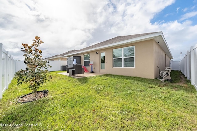 rear view of house featuring a yard, a patio, and central AC unit