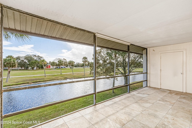 unfurnished sunroom featuring a water view