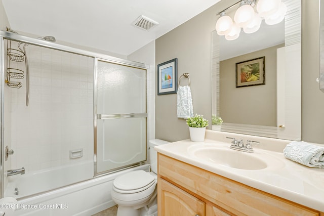 full bathroom with vanity, toilet, and bath / shower combo with glass door