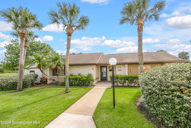 single story home featuring a front lawn