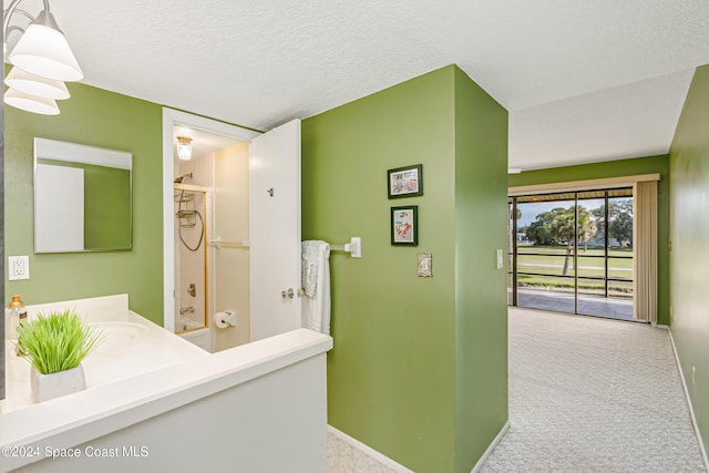 bathroom featuring vanity, shower / bathing tub combination, and a textured ceiling