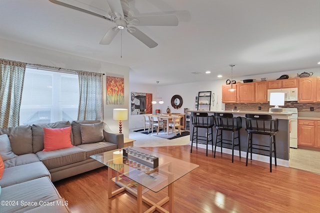 living room featuring light wood-type flooring and ceiling fan