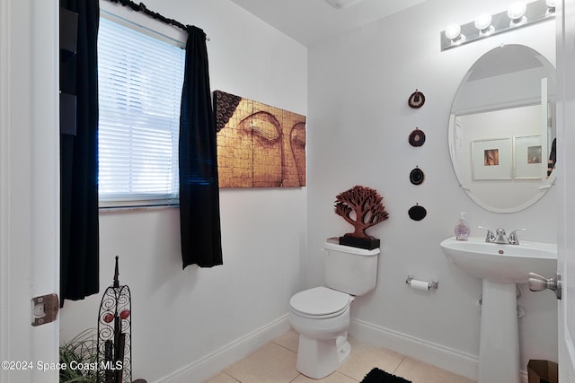 bathroom featuring tile patterned flooring, toilet, a healthy amount of sunlight, and sink