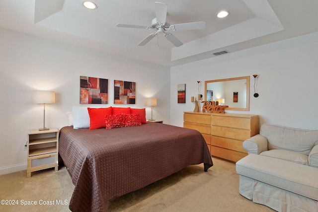 bedroom featuring a raised ceiling, ceiling fan, and carpet