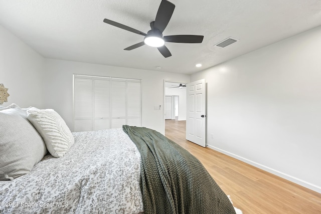 bedroom featuring hardwood / wood-style floors, a closet, and ceiling fan
