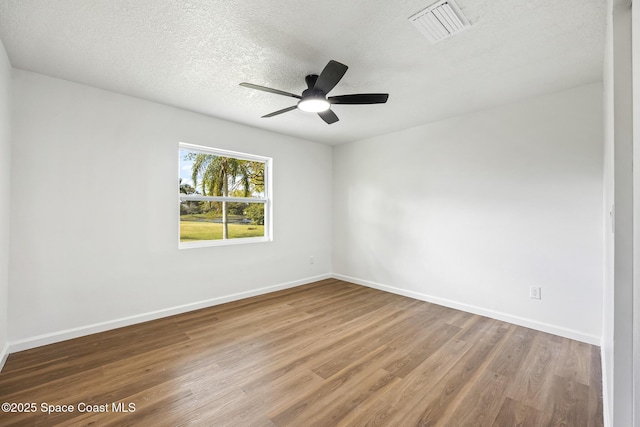 empty room featuring hardwood / wood-style flooring, ceiling fan, and a textured ceiling