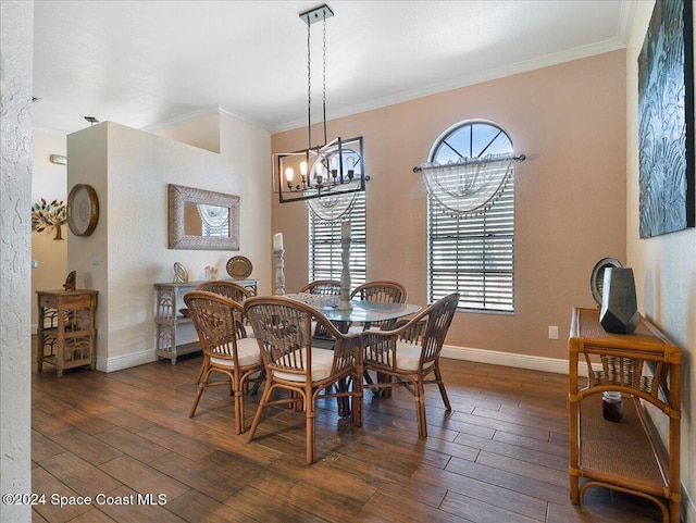 dining area with a healthy amount of sunlight, dark hardwood / wood-style flooring, ornamental molding, and an inviting chandelier