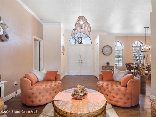 living room with a chandelier, crown molding, dark wood-type flooring, and a textured ceiling