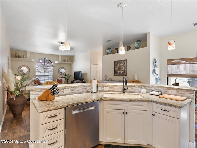 kitchen with light stone countertops, dark hardwood / wood-style flooring, sink, dishwasher, and hanging light fixtures