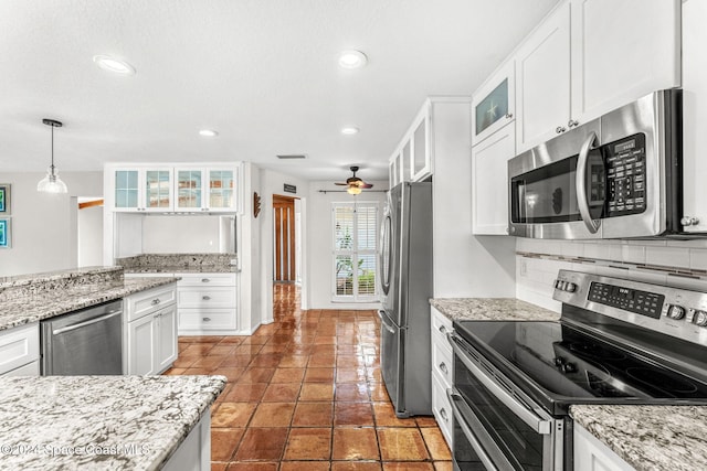 kitchen featuring ceiling fan, decorative backsplash, appliances with stainless steel finishes, decorative light fixtures, and white cabinetry