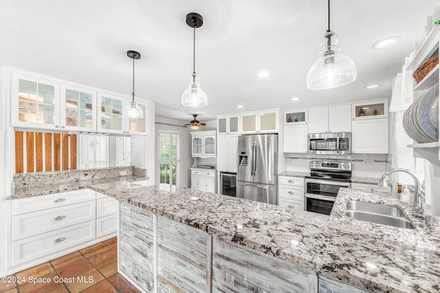 kitchen featuring sink, white cabinets, pendant lighting, and appliances with stainless steel finishes