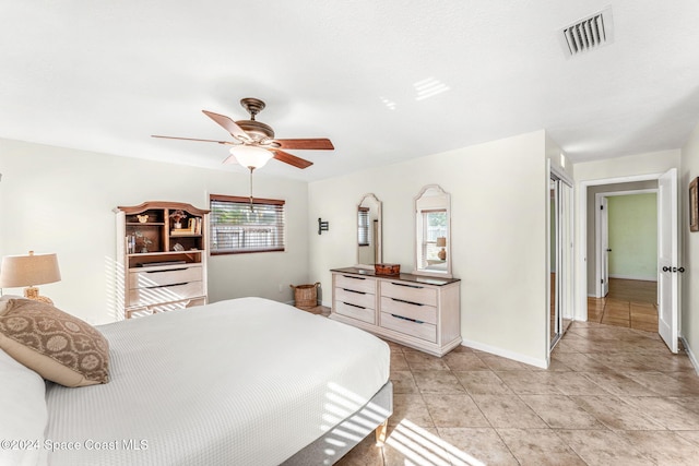 bedroom with light tile patterned floors, a closet, and ceiling fan