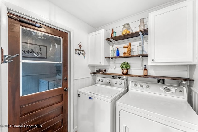 laundry area featuring separate washer and dryer and cabinets