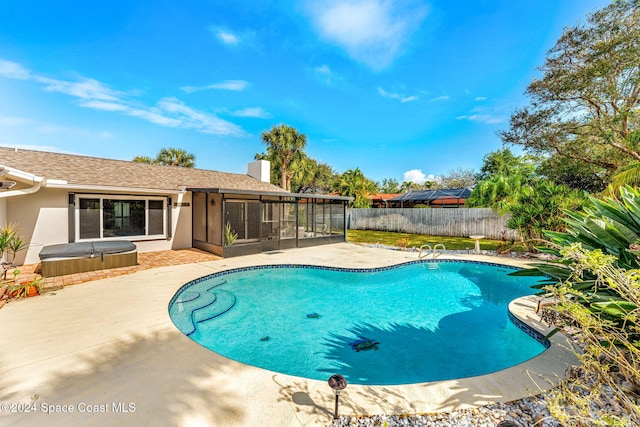 view of swimming pool with a sunroom, a patio, and a hot tub