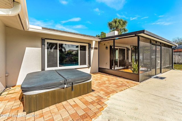 view of patio featuring a sunroom and a hot tub