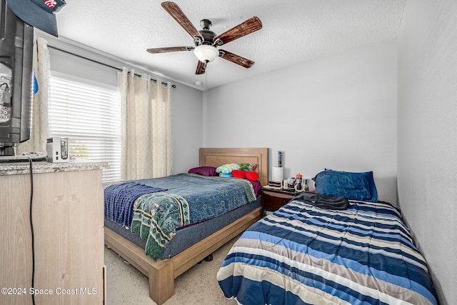 bedroom with carpet flooring, a textured ceiling, and ceiling fan