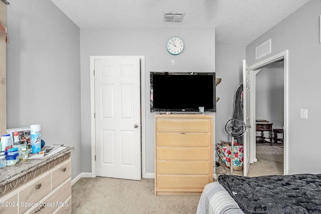 bedroom featuring a textured ceiling and light carpet