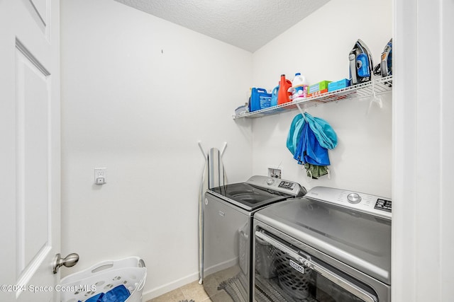 clothes washing area featuring washer and dryer and a textured ceiling