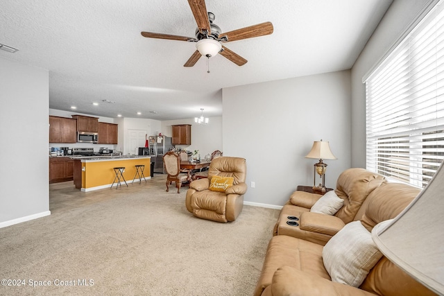 carpeted living room with ceiling fan with notable chandelier and a textured ceiling