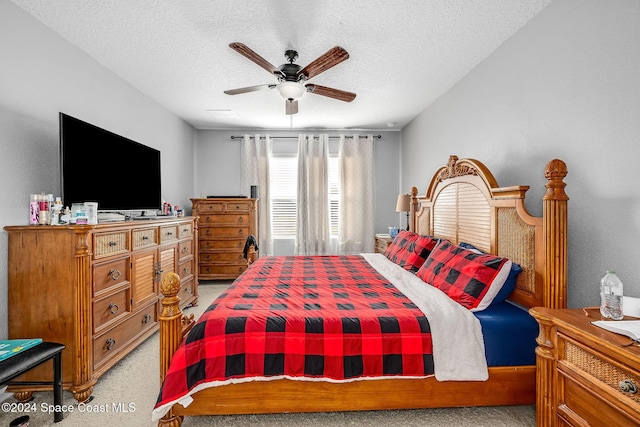 carpeted bedroom with ceiling fan and a textured ceiling